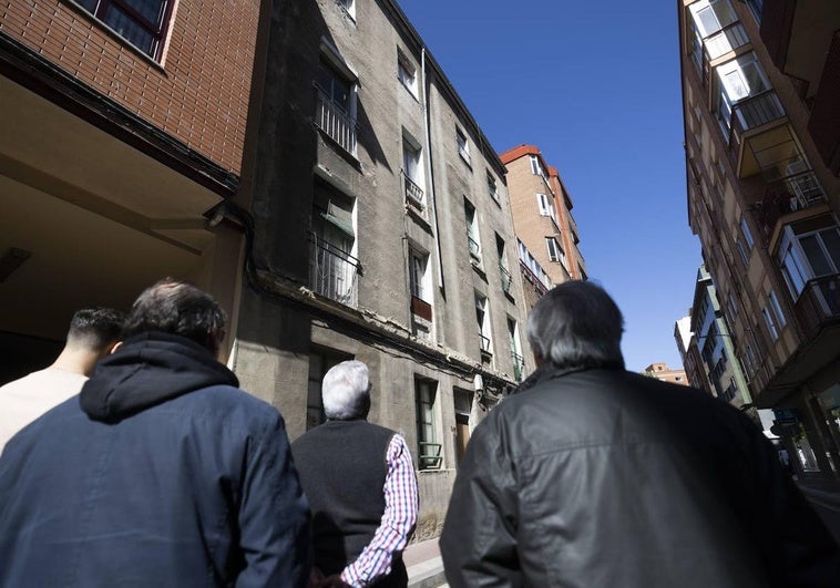 Vecinos del entorno de la calle Olmedo miran el edificio del número 4 sobre el que pesa una orden municipal de demolición desde marzo de 2023.