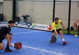 Una pareja sube a la red para golpear una bola.