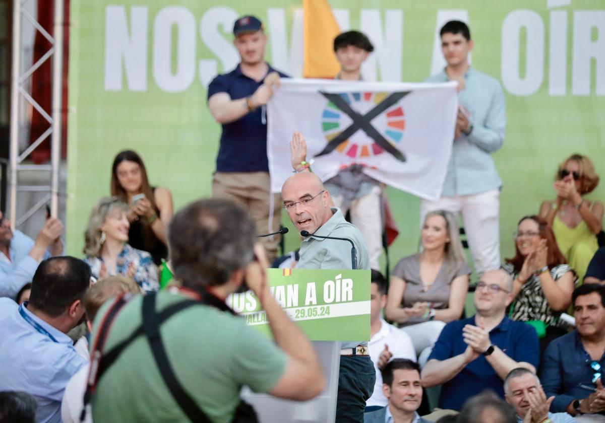 Jorge Buxadé señala a la pancarta con el logo de los Objetivos de Desarrollo Sostenible tachado.