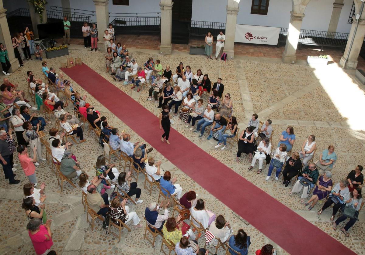 Una mujer desfila en el Palacio Episcopal ante la expectante mirada del público.