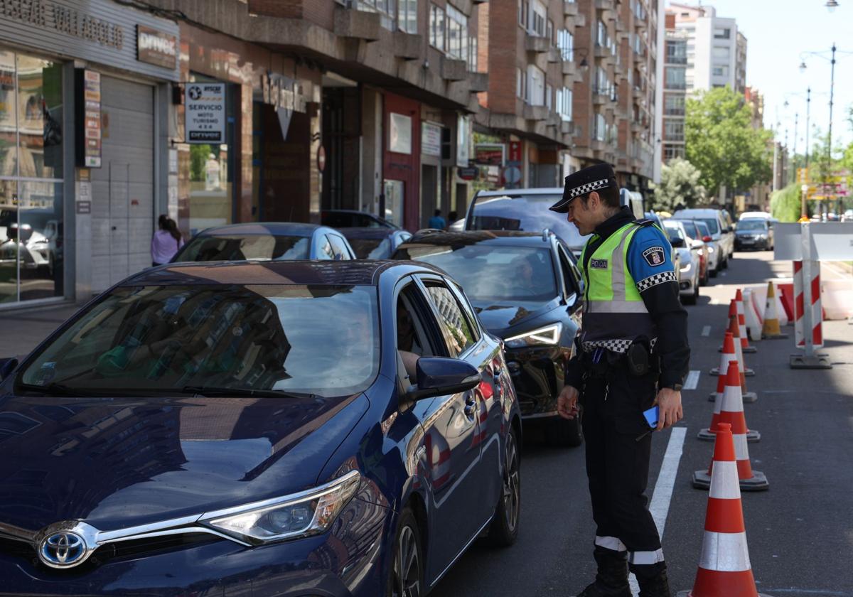 Un policía explica la situación a un conductor en el Paseo Hospital Militar, reducido a un carril.