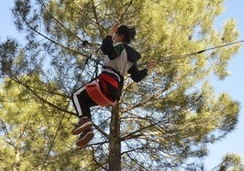 Una joven se lanza en tirolina en parque de aventuras de la provincia de Segovia.