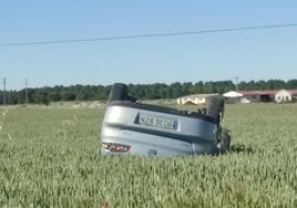 Coche volcado en las tierras de labor.