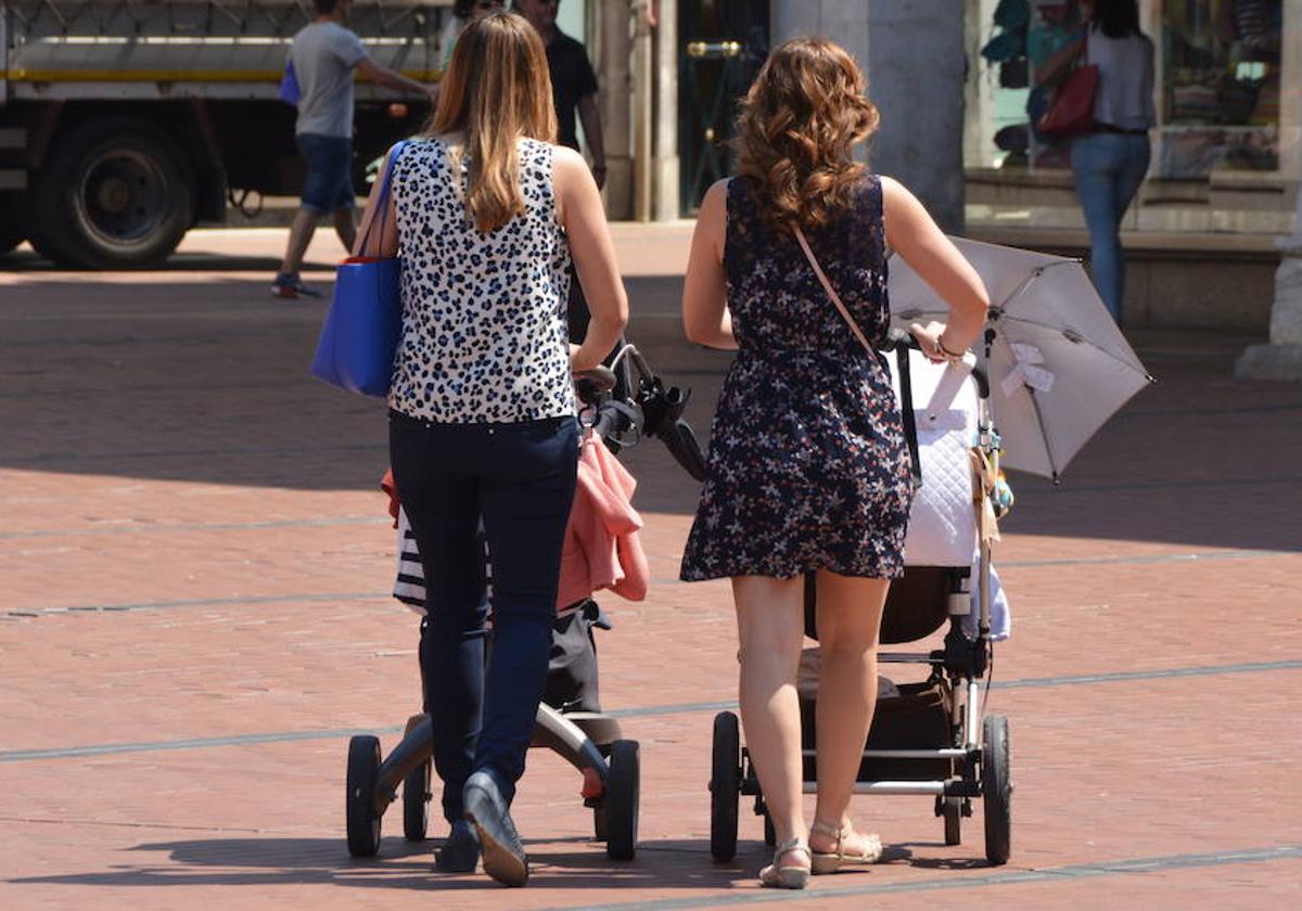 Dos madres pasean con sus bebés.