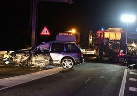 Imagen de archivo de efectivos de Emergencias y un coche accidentado durante la noche en la AP-61.