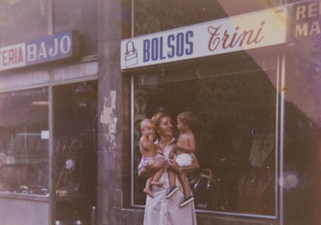 Trinidad Verdugo, 'Trini', en la puerta de la tienda con sus dos nietos mayores.