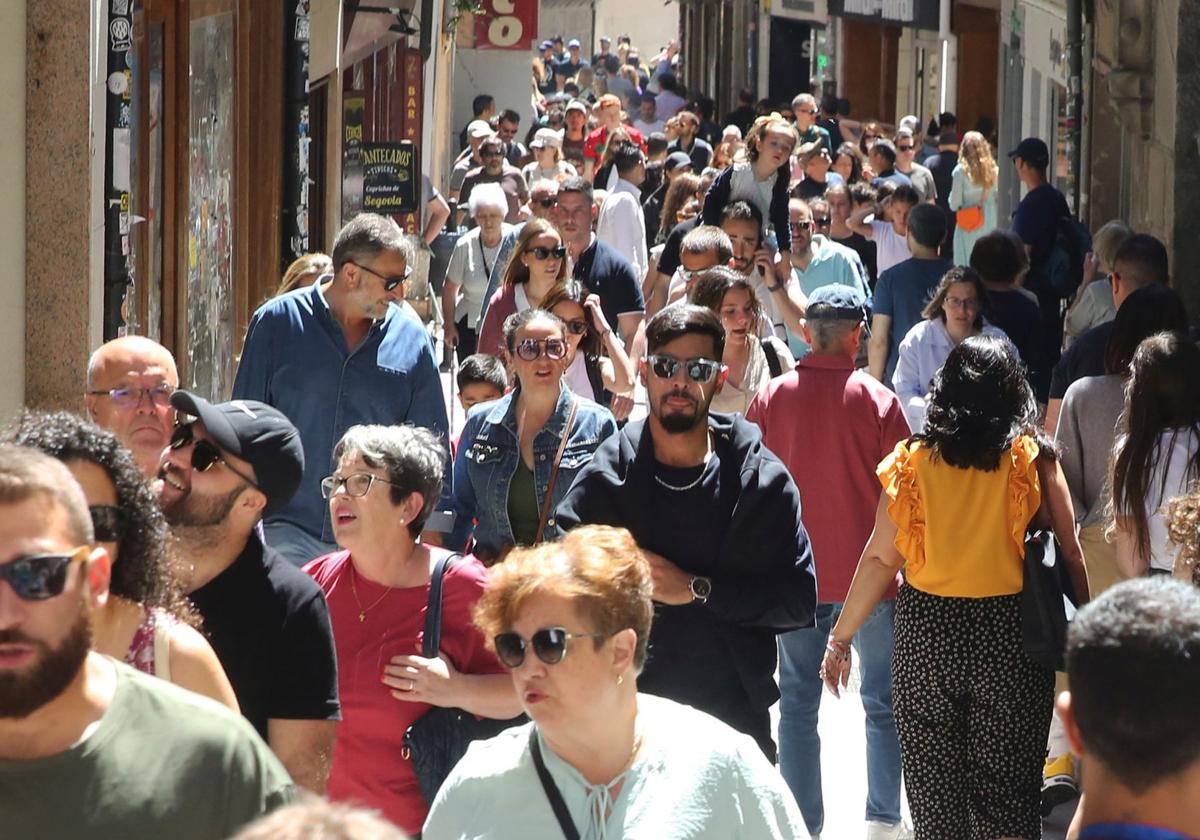 Decenas de turistas, por la Calle Real de Segovia.