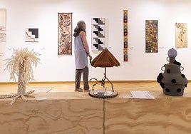 Una mujer observa piezas de la exposición 'De buena planta'.