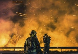 Operarios de las Brigadas de Refuerzo de Incendios Forestales (BRIF) luchan contra las llamas para extinguir el incendio.