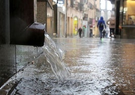 Un canalón suelta agua durante una tormenta en la ciudad de Segovia.