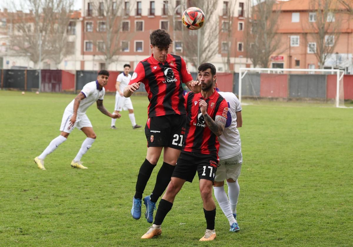 Dos jugadores del CD Laguna tratan de despejar el balón.