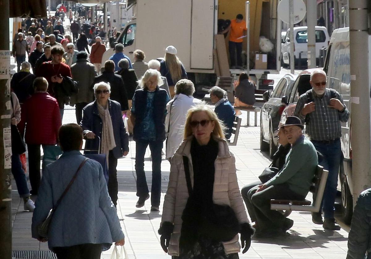 Multitud de personas pasean por una céntrica calle de la ciudad de Segovia.