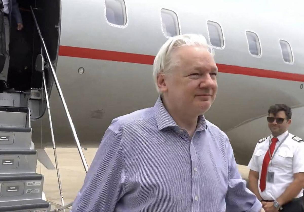 Julian Assang bajando de su vuelo desde Londres al llegar a Bangkok para hacer una escala.