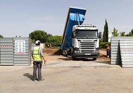 Un camión descarga tierra en una de las parcelas contaminadas en Pago la Barca.
