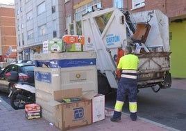 Recogida de cartón junto a un contenedor, sin las cajas bien plegadas.