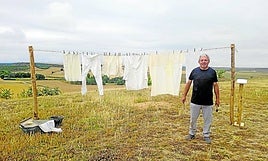 José Alonso junto a la ropa tendida y los objetos para lavar.