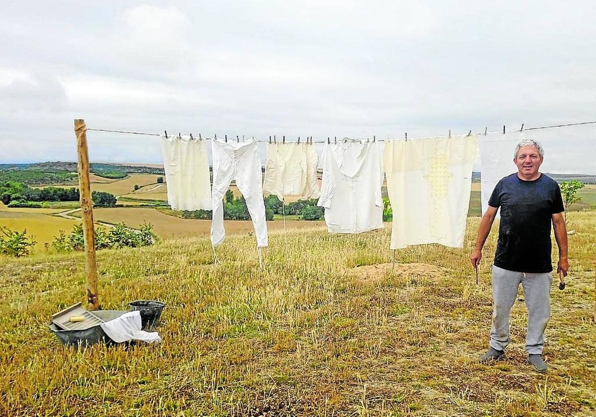 José Alonso junto a la ropa tendida y los objetos para lavar.