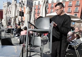 Un camarero coloca la terraza en la Plaza Mayor de Valladolid.