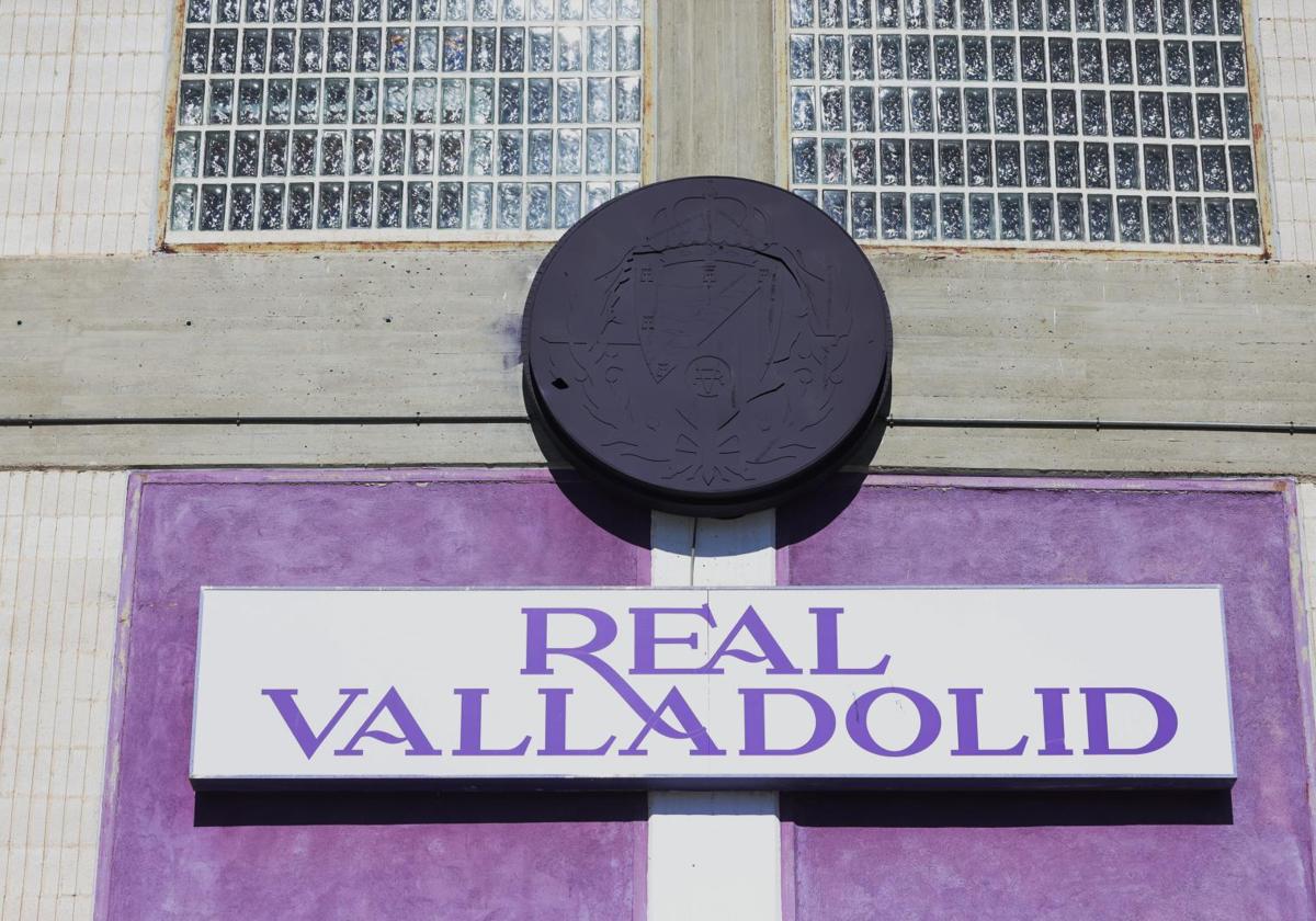 Imagen del escudo tradicional semioculto con pintura morada en la fachada del estadio Zorrilla.