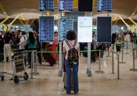 Una turista lee los paneles de información en el aeropuerto Adolfo Suárez Madrid-Barajas.