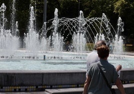 Paseantes junto a la fuente de la plaza de Zorrilla