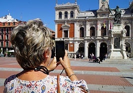 Una mujer toma una fotografía de la Plaza Mayor de Valladolid.