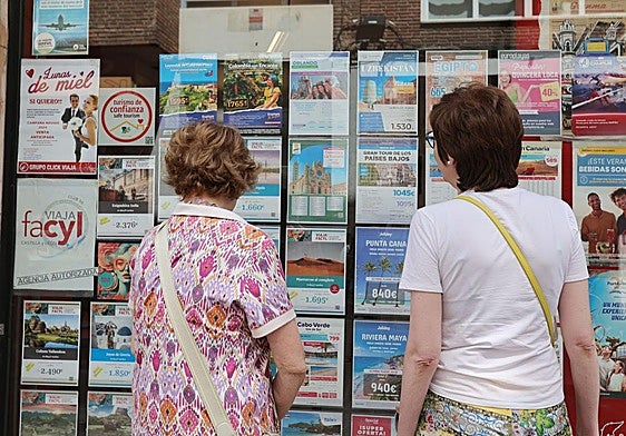 Dos mujeres miran el escaparate de una agencia de viajes de Palencia.