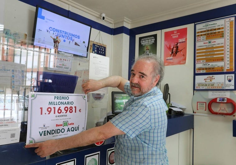 Luis Fernando Alonso Blanco sujeta el cartel que anuncia el premio.