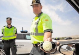 Dos agentes, con un alcoholímetro en una imagen de archivo.