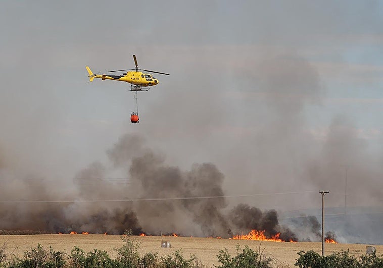 Un helicóptero interviene en las labores de extinción del incendio en la Cistérniga.
