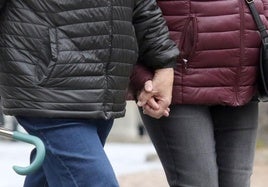 Una pareja caminando por la calle de la mano.