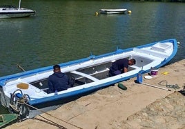 Los voluntarios de Los Amigos del Pisuerga pintan la patera que portará la imagen de la Virgen del Carmen el domingo.