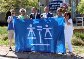 Representantes del Colegio de Abogados de Segovia despliegan la bandera de la justicia gratuita en la glorieta dedicada al turno de oficio.