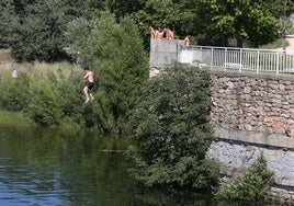 Un grupo de jóvenes realiza saltos desde el entorno de la CL-601 hasta el Pontón Alto.