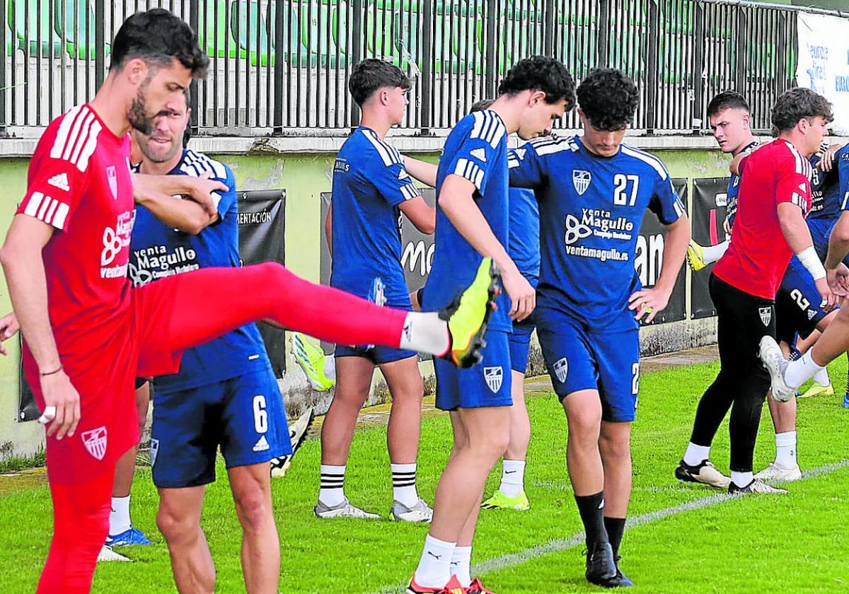 Jugadores de la Segoviana realizan estiramientos al inicio del entrenamiento.