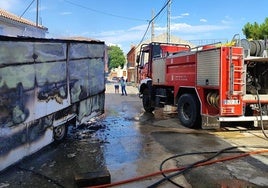 A la izquierda, el remolque calcinado por el fuego que ha sido sofocado por la Agrupación de Voluntarios de Protección Civil de Sepúlveda.