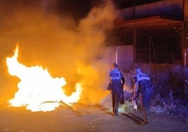 Los agentes de la Policía Local de Segovia tratan de controlar el fuego del contenedor.