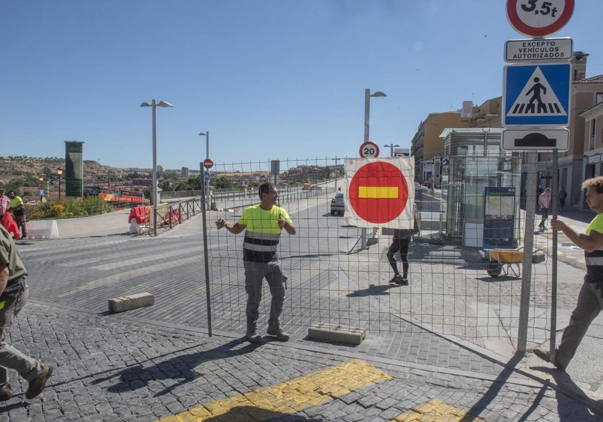 Momento en el que los trabajadores colocan la valla del corte de tráfico por obras en Padre Claret, este lunes.