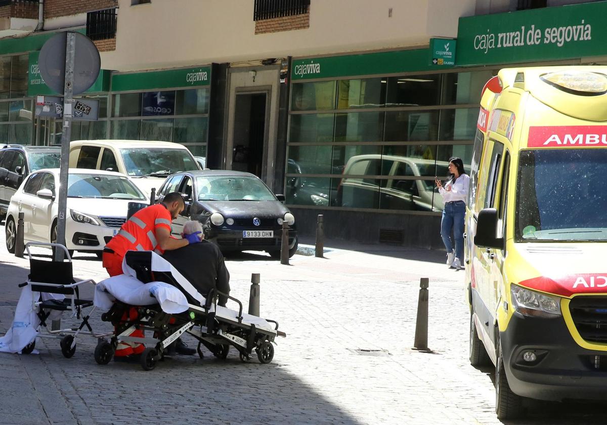 Un trabajador del transporte de emergencias atiende a un viandante en Segovia.