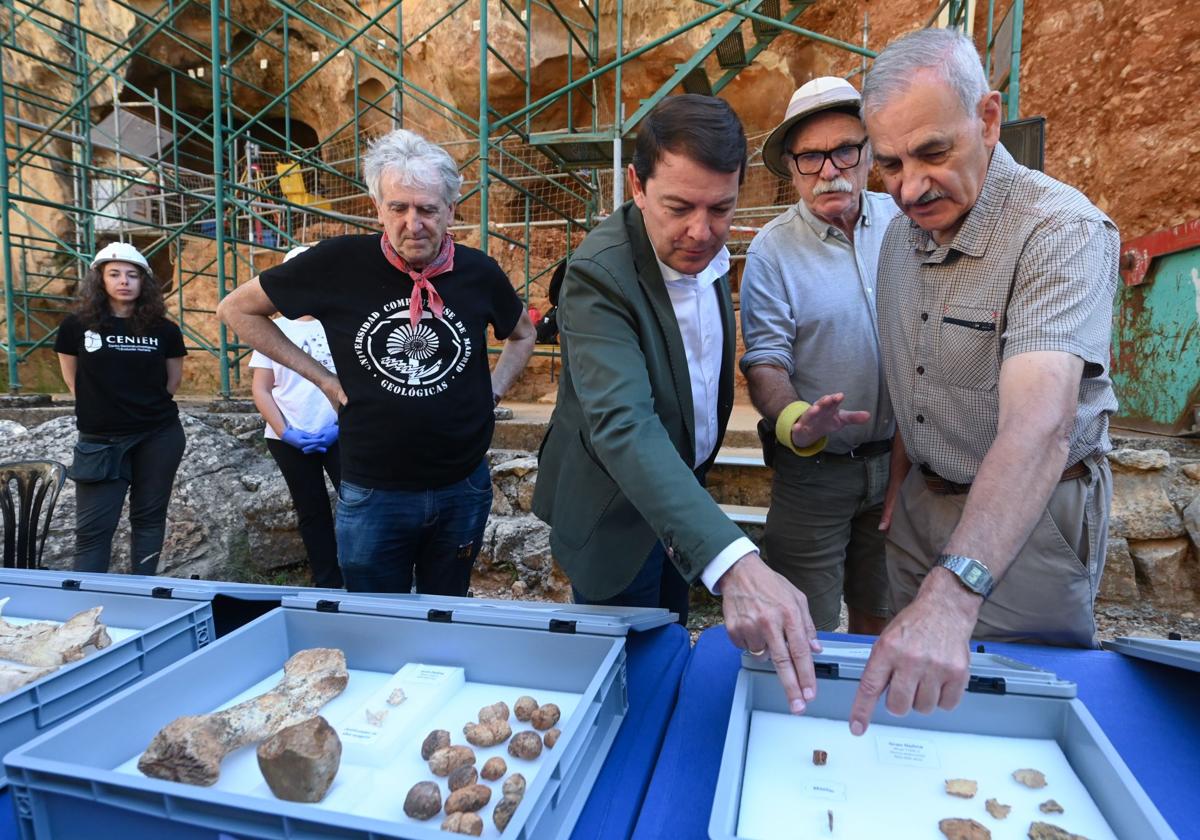 Juan Luis Arsuaga, Alfonso Fernández Mañueco, Eudald Carbonell y José María Bermúdez de Castro observan fósiles extraídos durante esta campaña en Atapuerca.