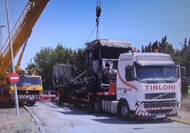 El camión incendiado, retirado por la grúa.