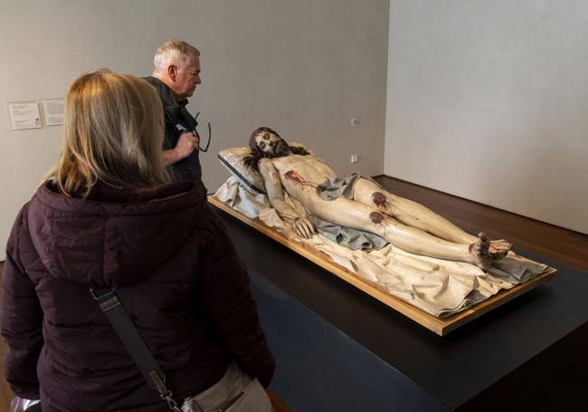 Dos visitantes observan el Yacente en el Museo Nacional de Escultura.