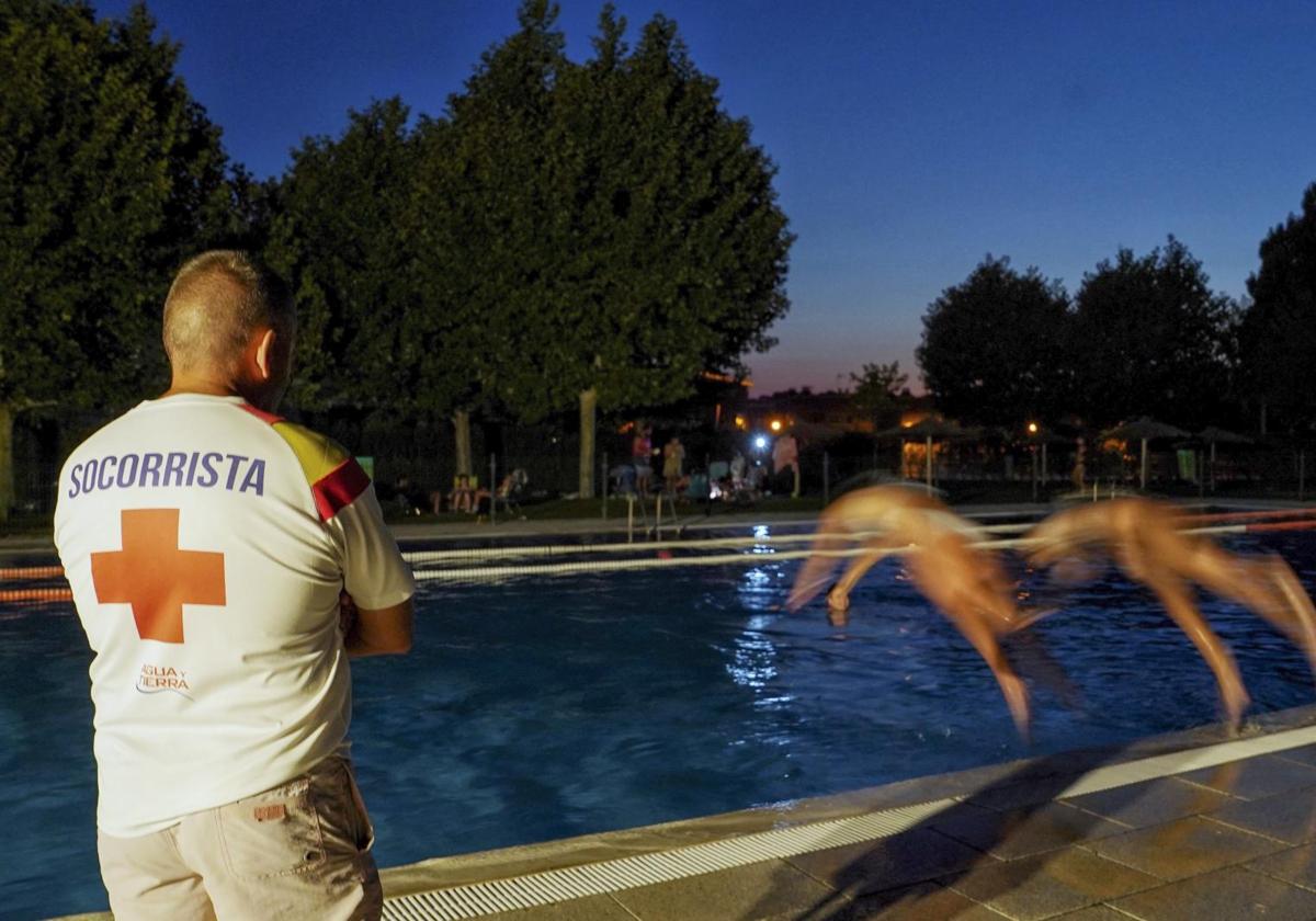 Un socorrista vigila la piscina de Viana, que abre estos días hasta las once de la noche.