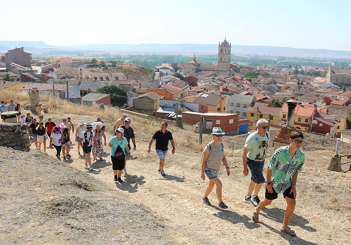 Numerosos visitantes se dirigen hacia las bodegas, con el pueblo de Dueñas debajo.