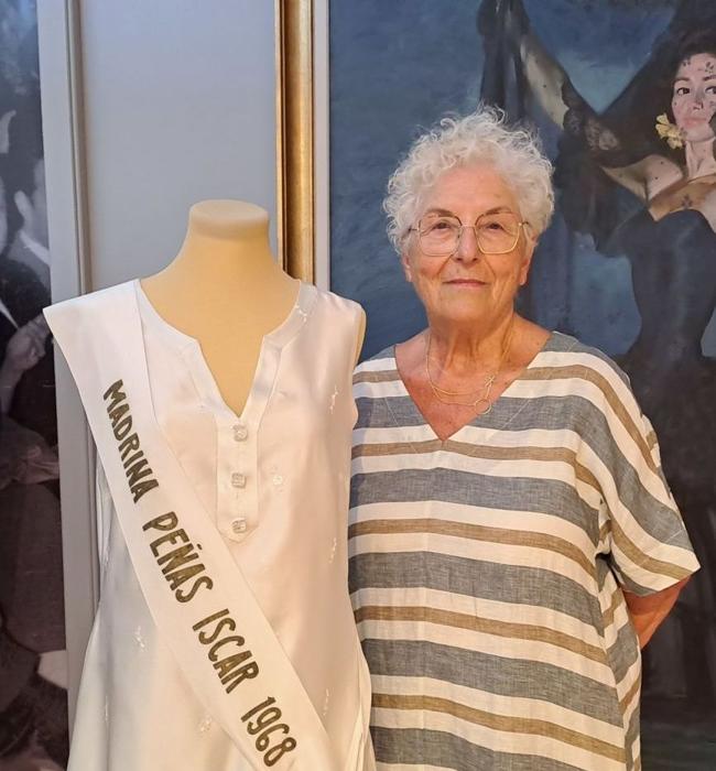 Martina Rodríguez, reina de las madrinas de las peñas de 1968 junto al vestido que lució el día de su proclamación y que puede verse en la exposición.