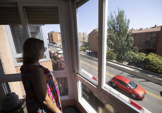 Pilar Fernández mira los coches desde la terraza de su vivienda.