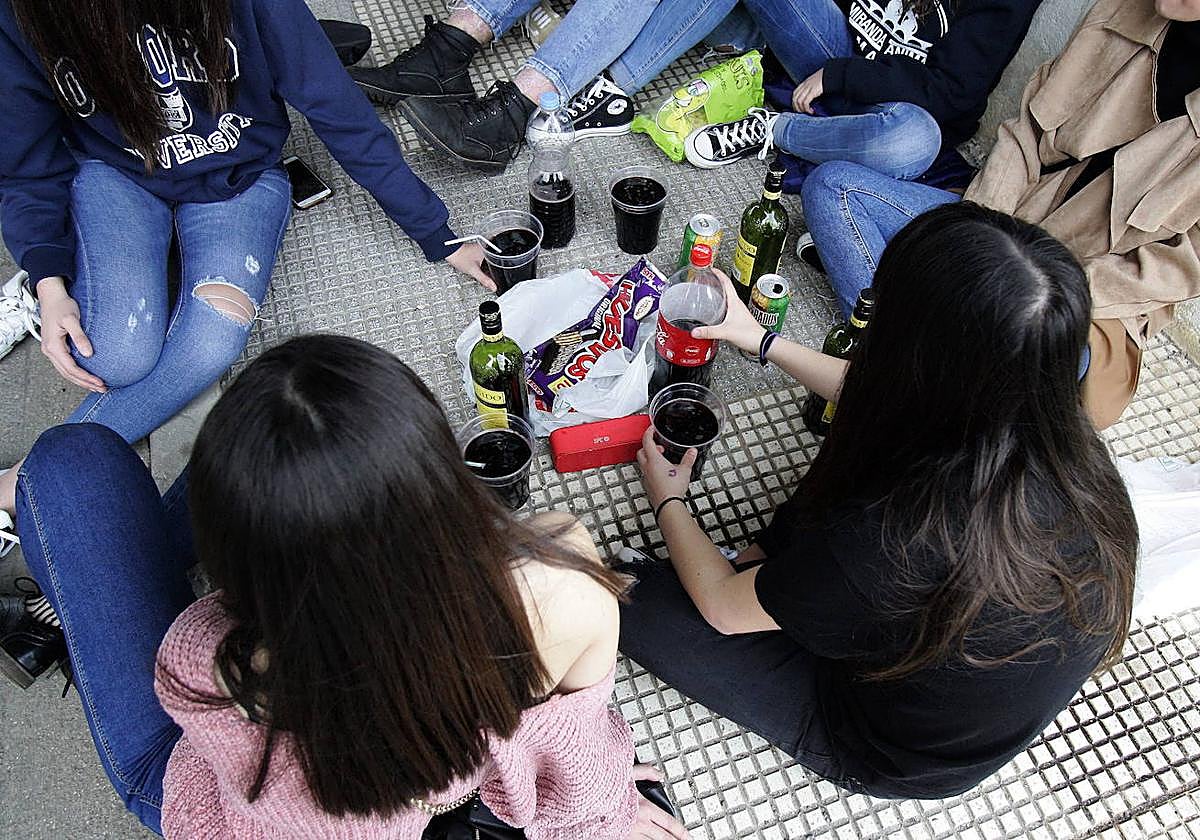 Un grupo de jóvenes realiza un botellón.