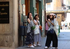 Turistas asiáticas comen un helado junto a la Plaza Mayor de Segovia.