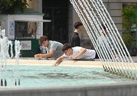 Un grupo de jóvenes se refresca en la fuente de Zorrilla este martes por la tarde.