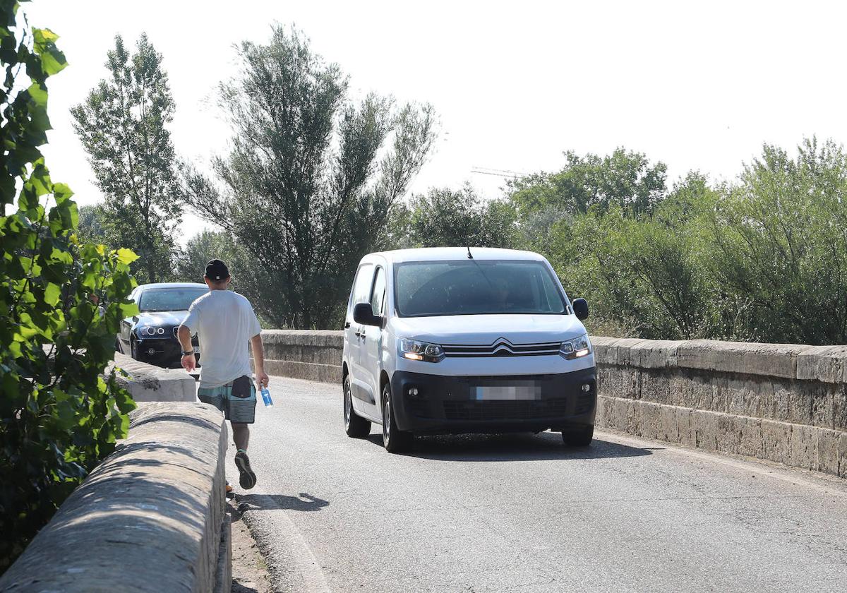 Un joven camina por el puente de Villamuriel sobre el río Carrión que va a mejorarse.